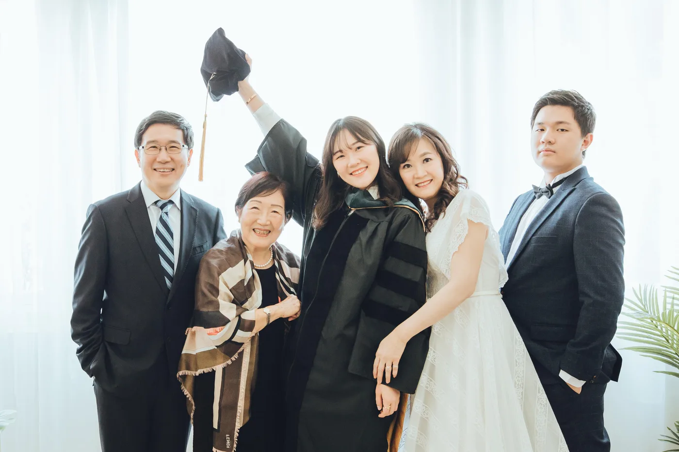 Graduation family photoshoot Singapore - graduate in regalia with family