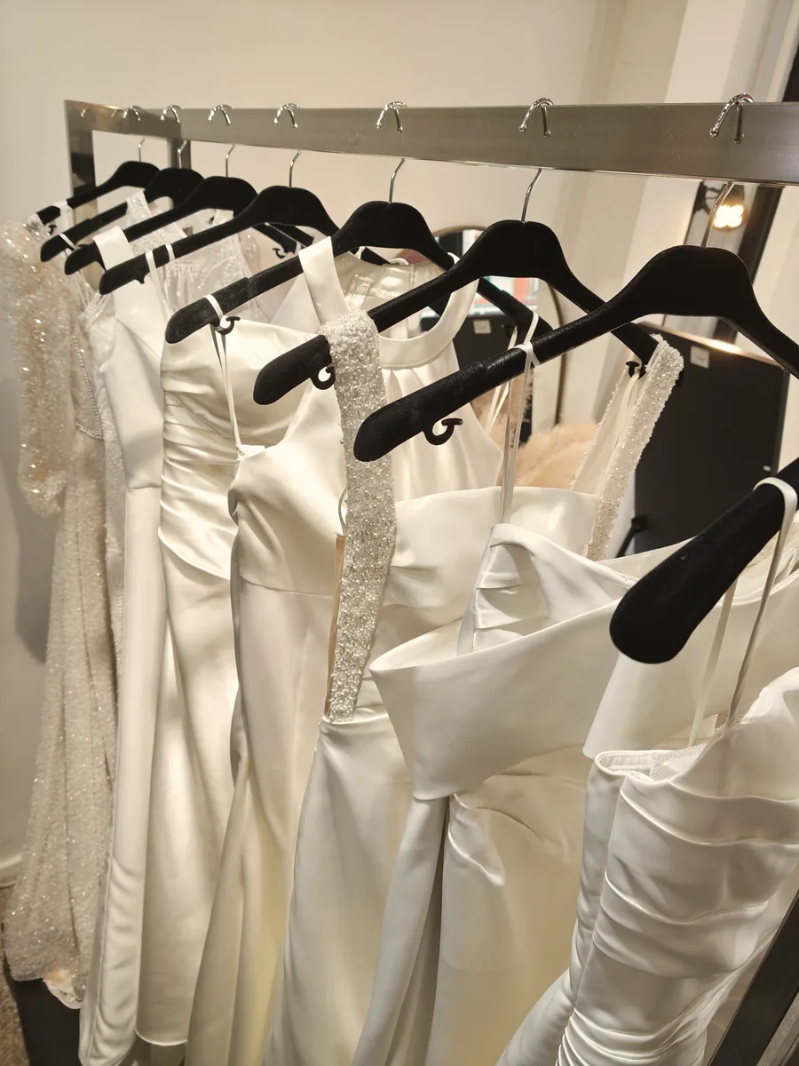 A row of satin gowns on velvet hangers